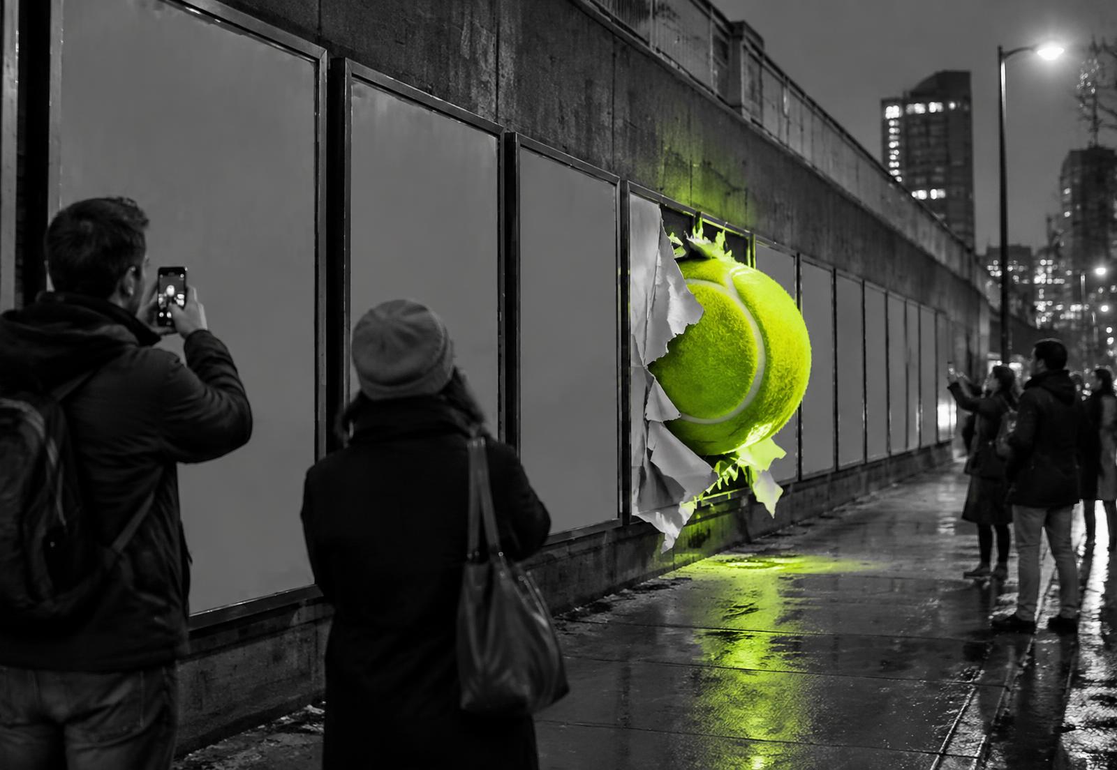 An ordinary row of black-and-white billboard panels on a wet city street, with one poster tearing open as a huge neon green object bursts through while passers-by photograph it